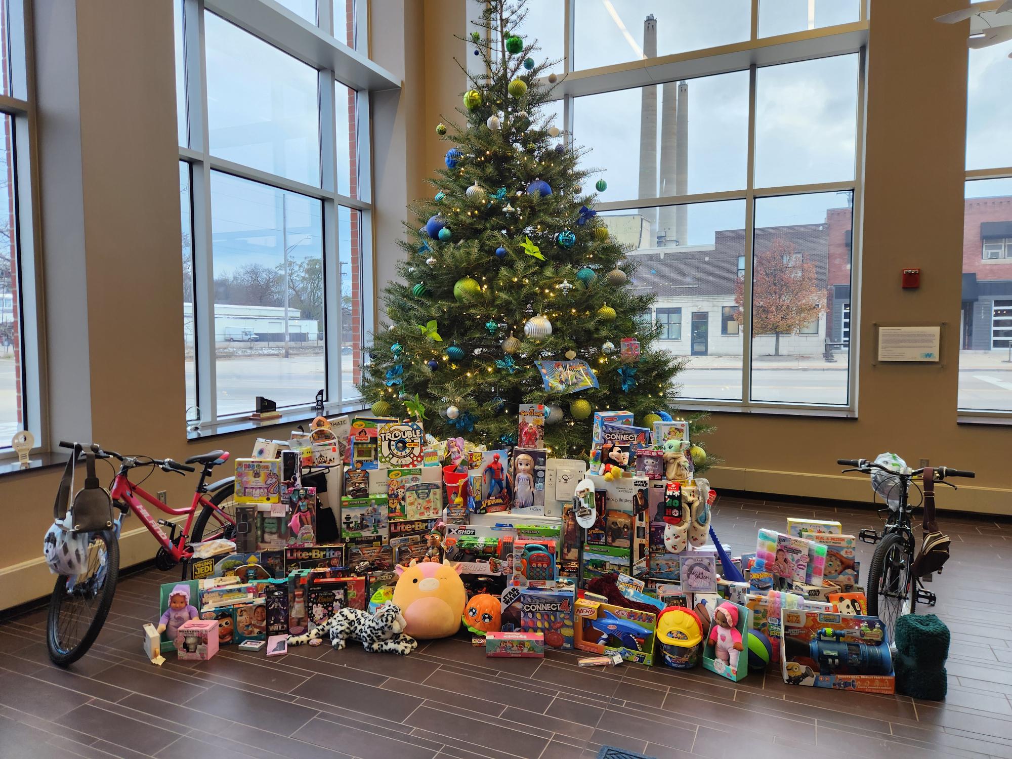 pile of presents in front of a christmas tree